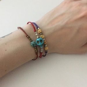 Three string and bead bracelets with skull motif
